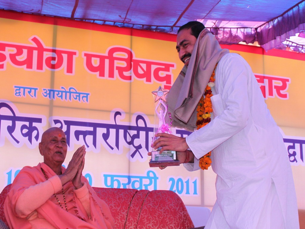 Sunil Yogachrya receives a trophy from Swami Satymitrananad ji president of Bharat Mata Mandir during a 2011 Yoga Parishad event